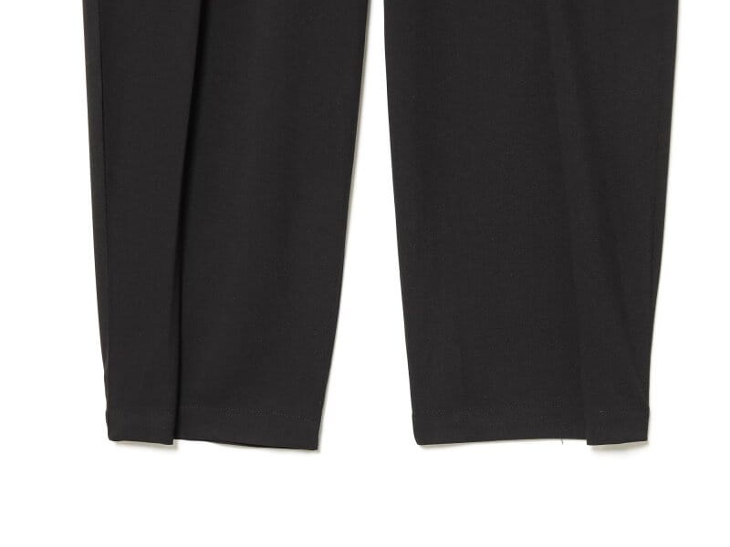 Pantalons noirs à coupe slim, finition en tissu mat lisse, mettant en valeur le design taille haute plissé à jambes évasées.