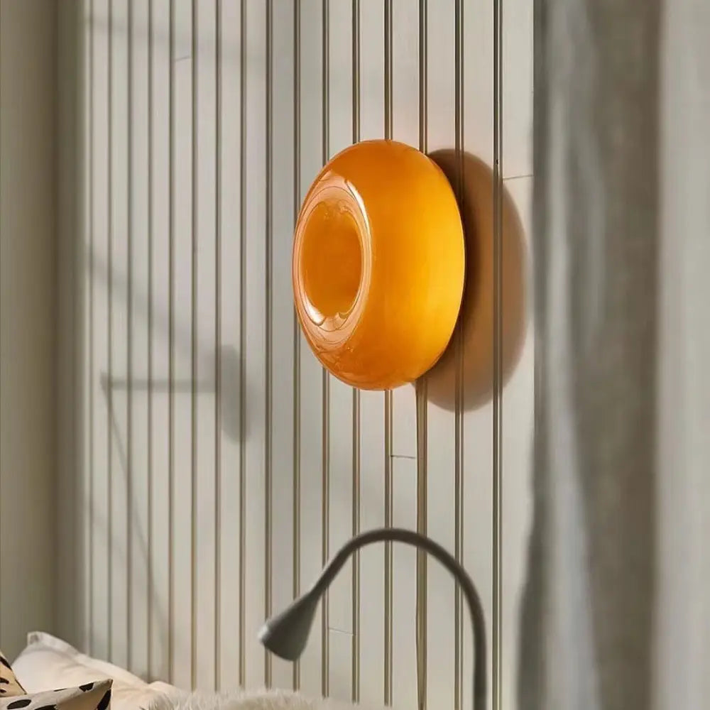 Petit porte-savon en silicone translucide orange éclatant, au design arrondi et lisse, monté au mur dans le cadre du produit de luminaire mural tactile en acrylique orange, à luminosité réglable.