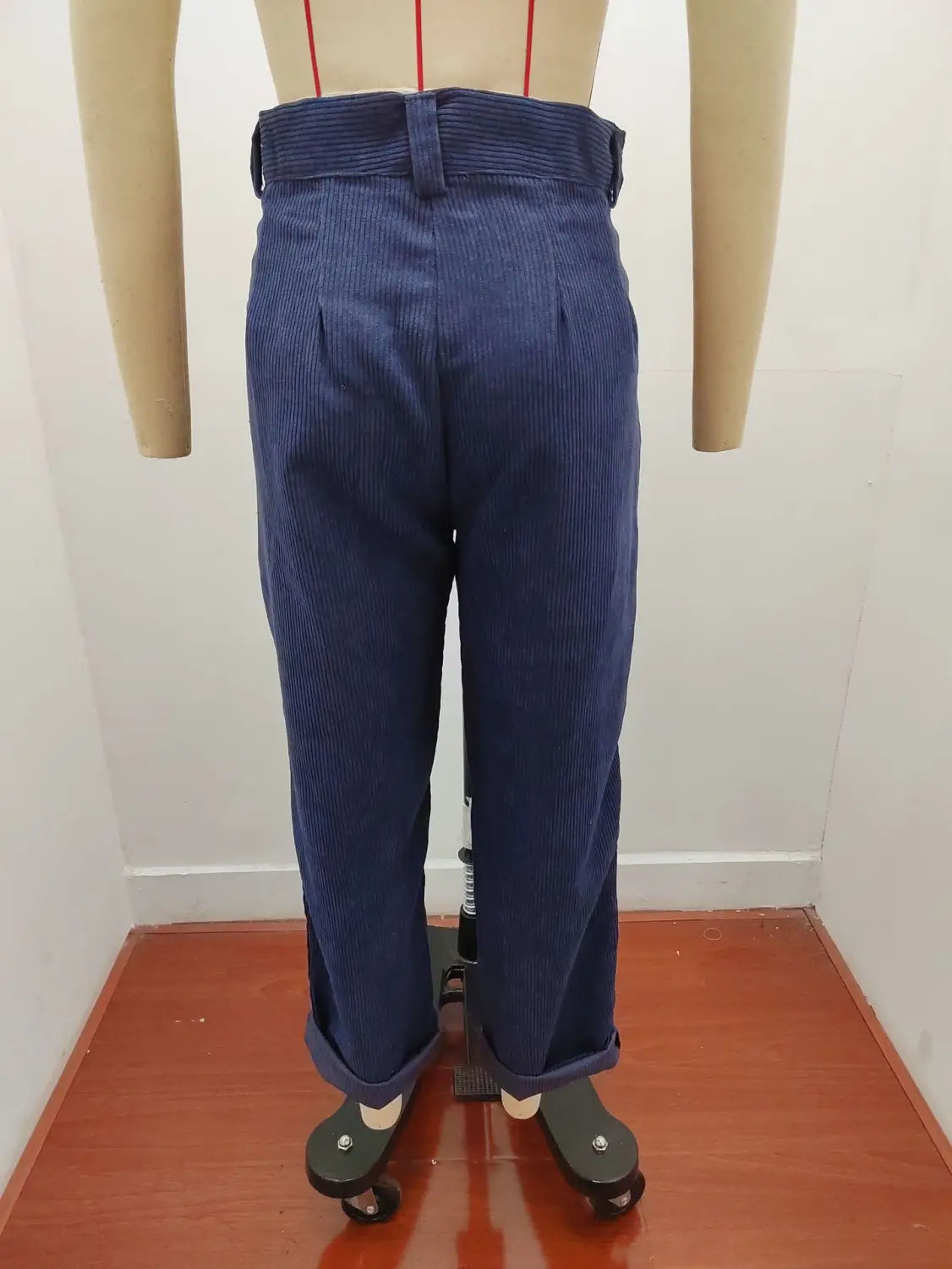 Pantalon en velours côtelé bleu foncé taille haute ample avec des plis, présenté sur un mannequin.