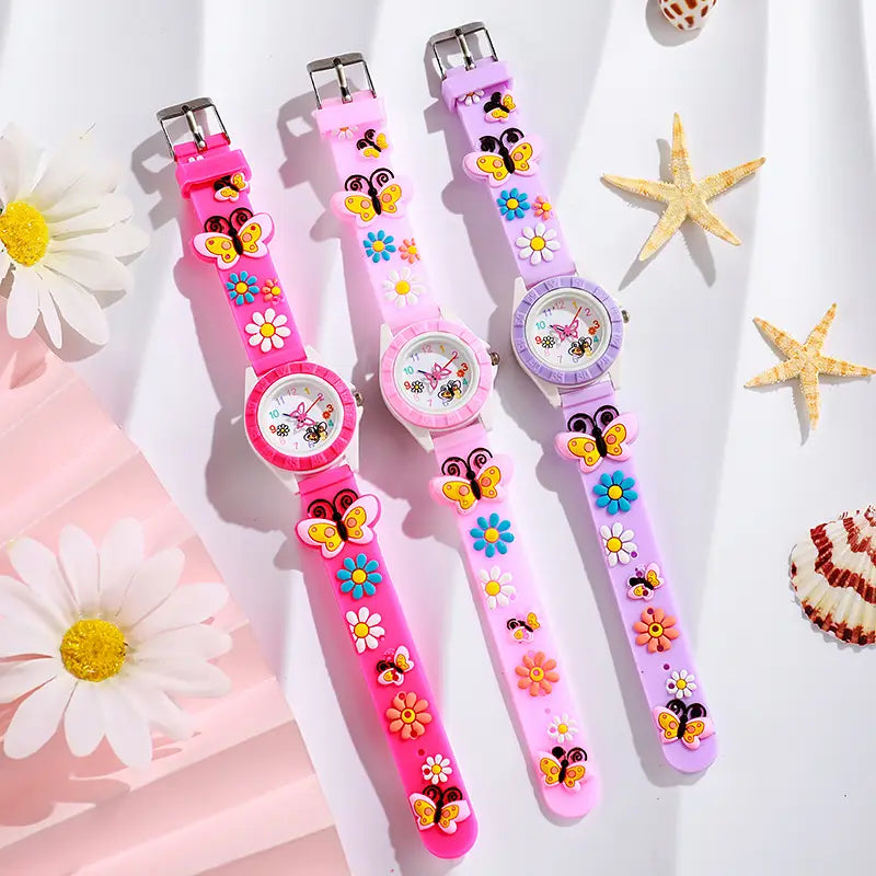 Girls butterfly silicone quartz watches in pink lavender and light pink with colorful butterfly and flower charms on silicone straps.