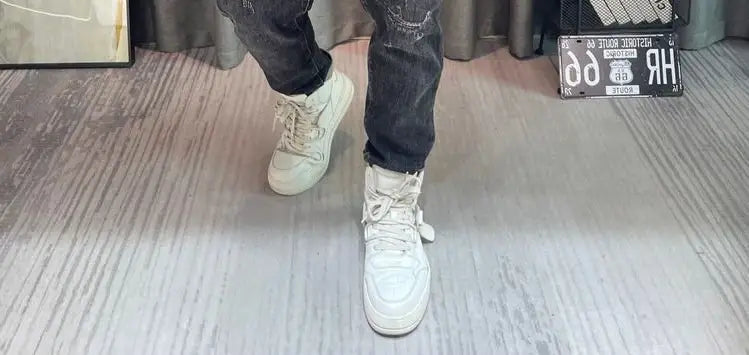 Baskets montantes blanches à la conception minimaliste et épurée, avec une touche de branding discrète, associées à un pull-over en maille à empiècement contrastant pour homme, manches longues.