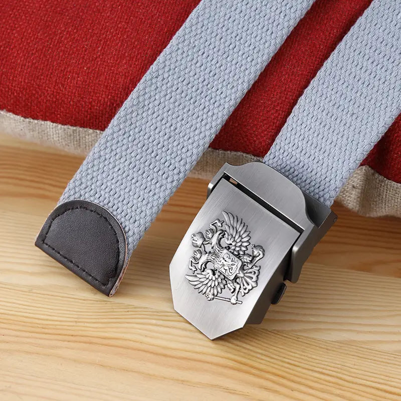 Ceinture tactique en toile gris clair pour hommes, avec une boucle en métal à finition ton argent gravée d’un emblème d’aigle bicéphale.