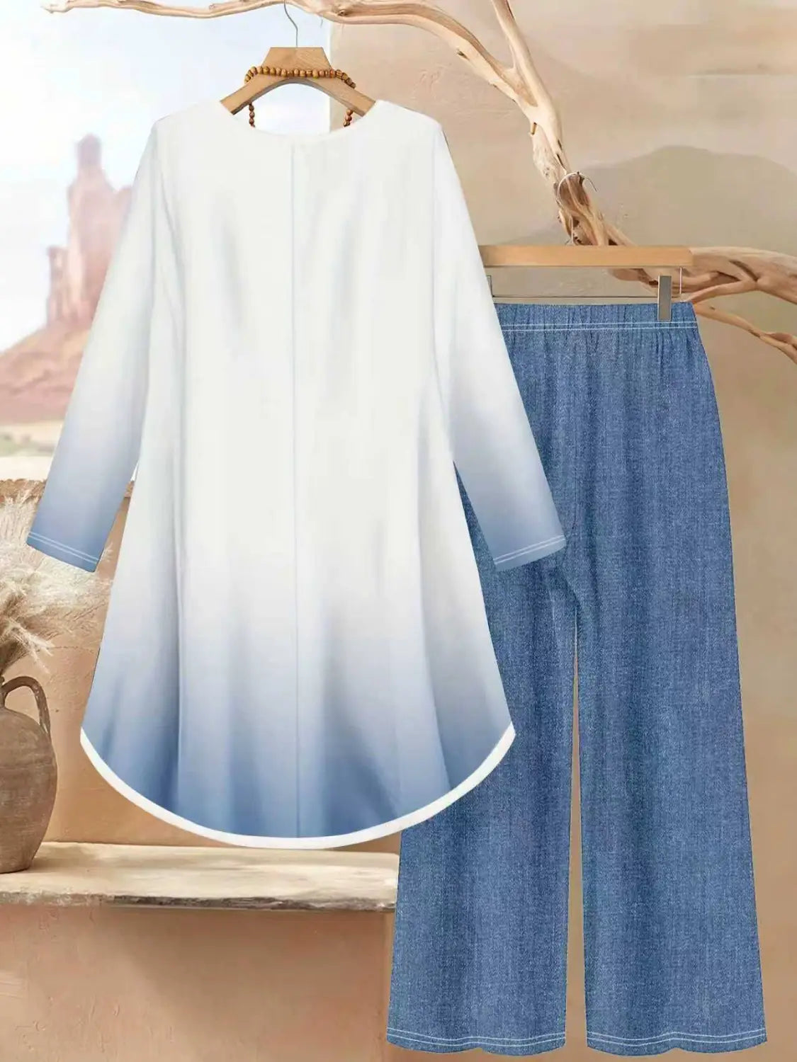 Zweiteiliges Outfit mit Blumendruck: Ein weißer und blauer Farbverlauf-Langarmoberteil mit entspanntem Schnitt, kombiniert mit Jeanshosen mit weitem Bein.