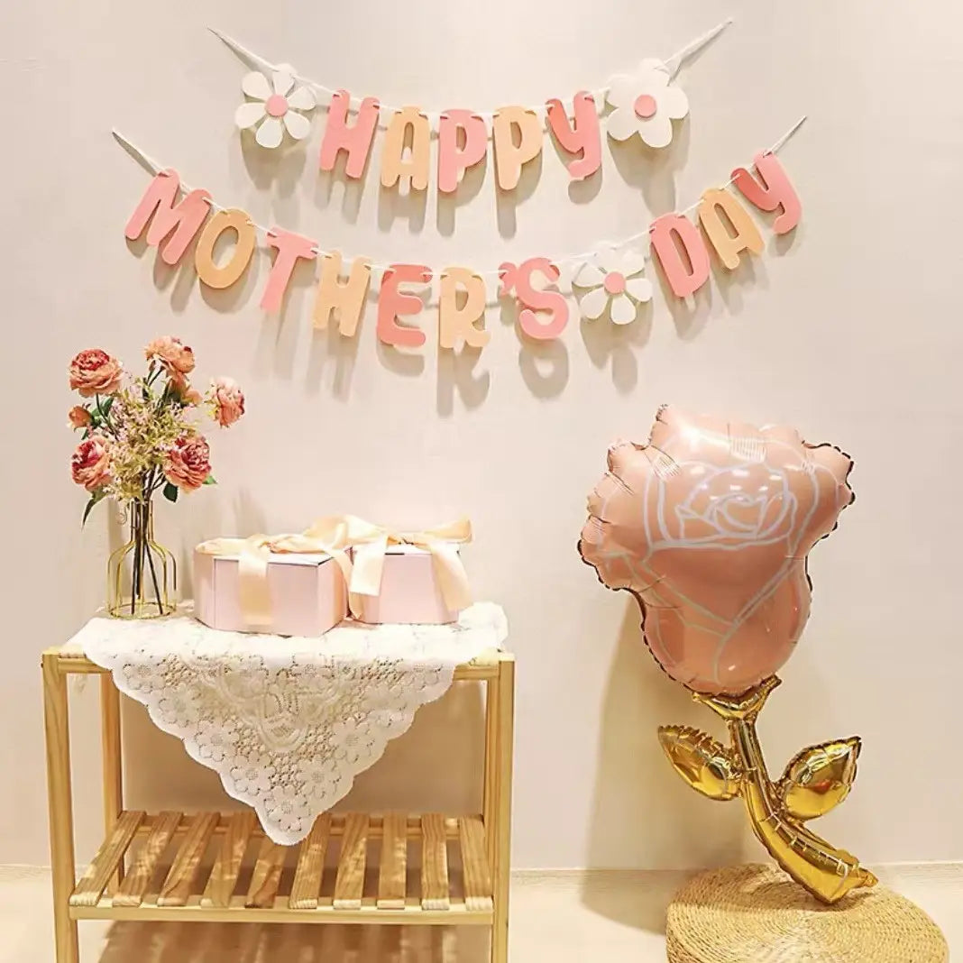 a mothers day daisy paper banner wall decor featuring a pink rose shaped balloon with a gold stem and leaves in an outlined design