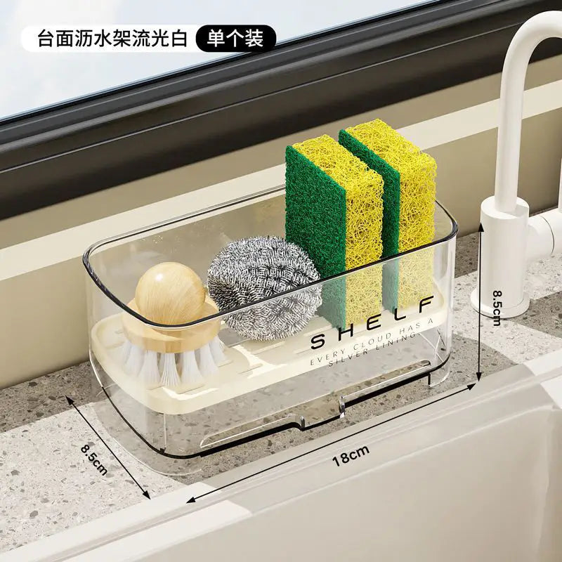 Organizador transparente de fregadero de cocina de plástico con estante impreso en el lateral, que sujeta utensilios de limpieza como esponjas y un cepillo para organizar el fregadero de cocina y usar la rejilla de drenaje.