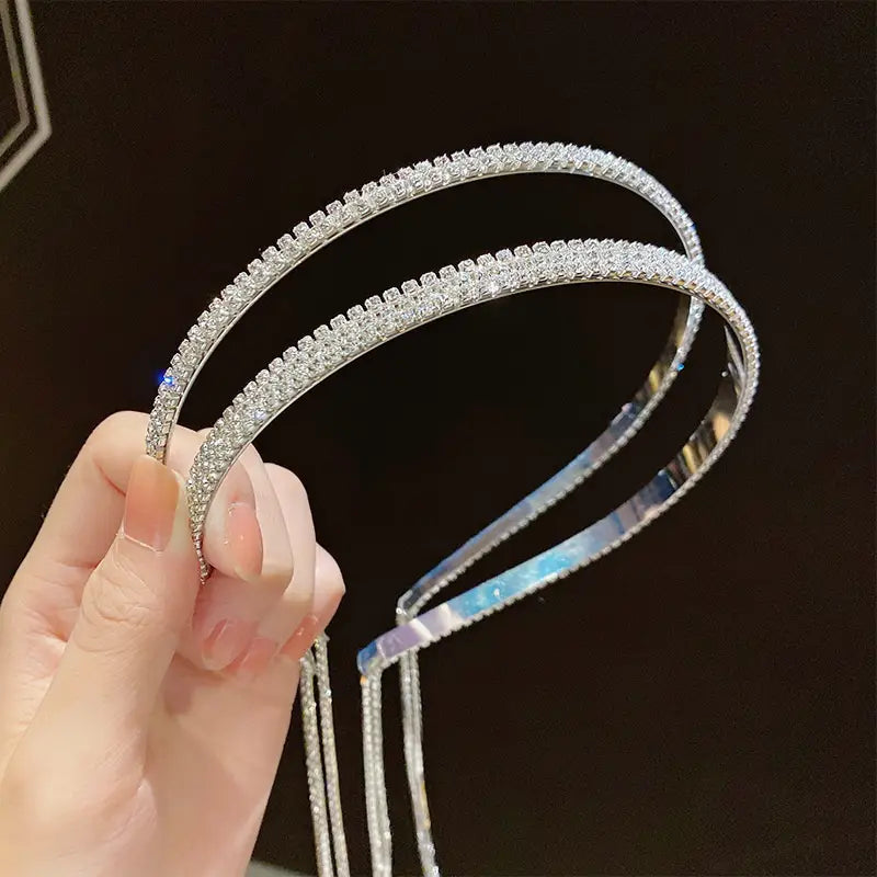 A sparkling silver crystal rhinestone tassel headband for women adorned with a continuous row of clear faceted crystals along its curved band.