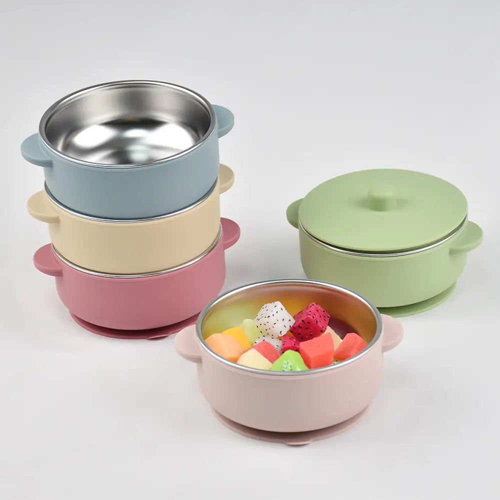Pastellrosa Baby-Schulungs- bzw. Trainingsschüssel aus Silikon mit Innenauskleidung aus Edelstahl und passendem Deckel, konzipiert für das Zufüttern und Füttern.
