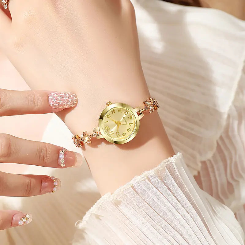 Gold-toned women rhinestone quartz watch with a delicate crystal leaf floral bracelet design and a round face featuring gold numerals.