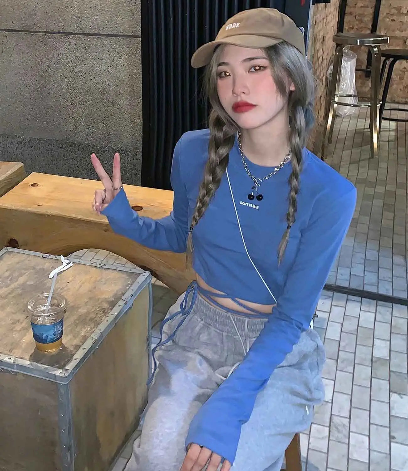 Blaues Damen-Langarm-Crisscross-Crop-Top mit dezentem weißem Logodruck auf der Brust.