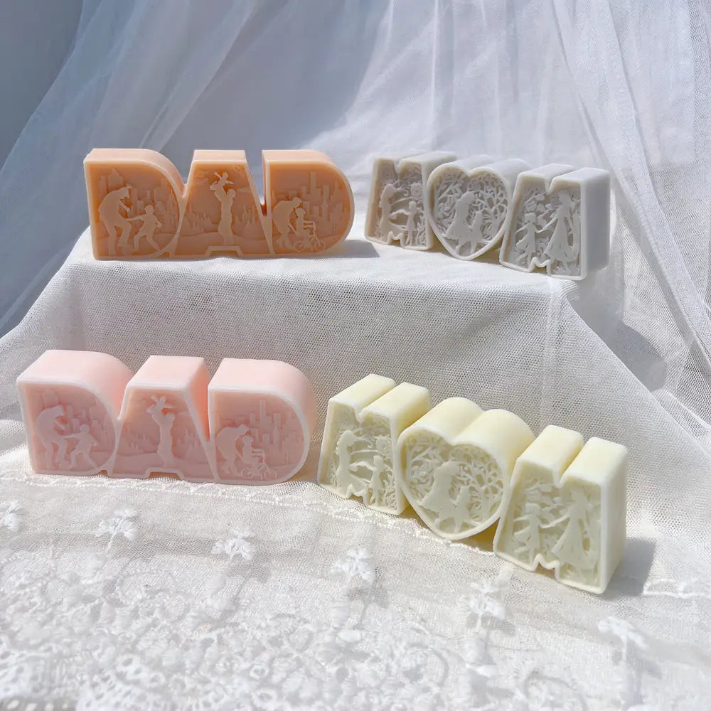 pastillas de jabón de colores pastel con forma de las palabras papá y mamá, con escenas familiares talladas con gran detalle elaboradas mediante un molde de silicona para velas con el título papá mamá letra molde de silicona para vela.