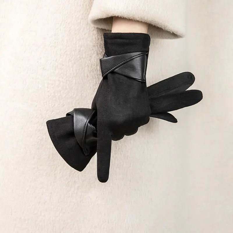 black women’s touchscreen winter gloves with a thermal suede main body and shiny leather straps forming an elegant knot at the wrist visible from the back side