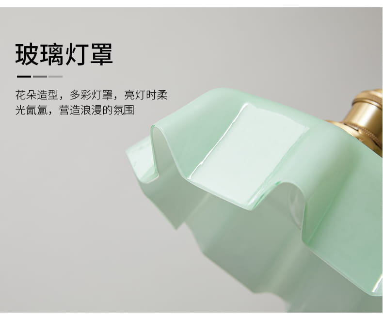 Un luminaire suspendu à jupe florale en verre vert menthe avec une conception froncée et une tête de lampe en cuivre polie montrée depuis l’avant.