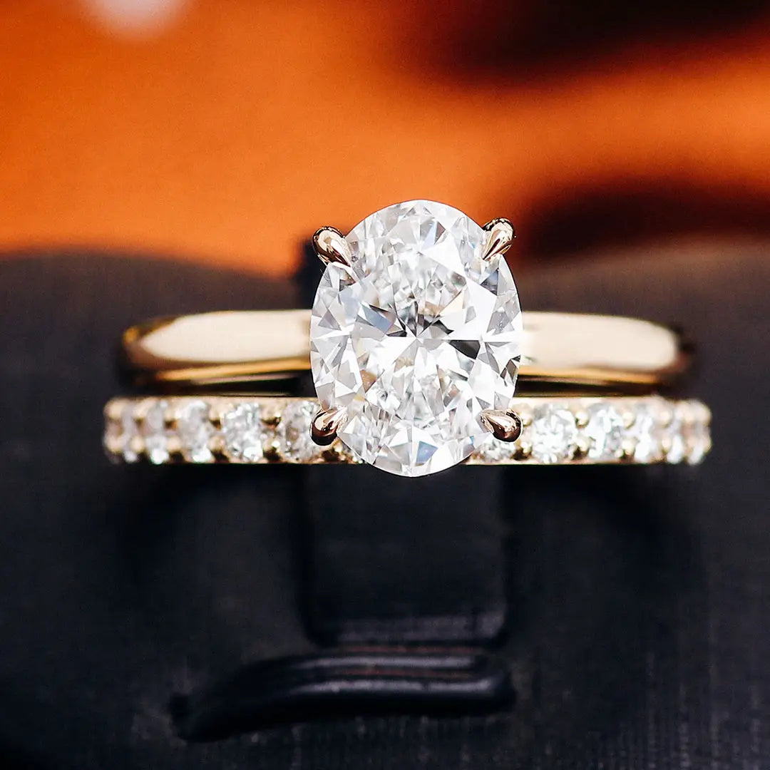 Ensemble de bague de fiançailles en diamant de laboratoire ovale, or, présentant une bague de fiançailles à diamant ovale éclatant avec un bracelet en or et une alliance assortie sertie pavée.