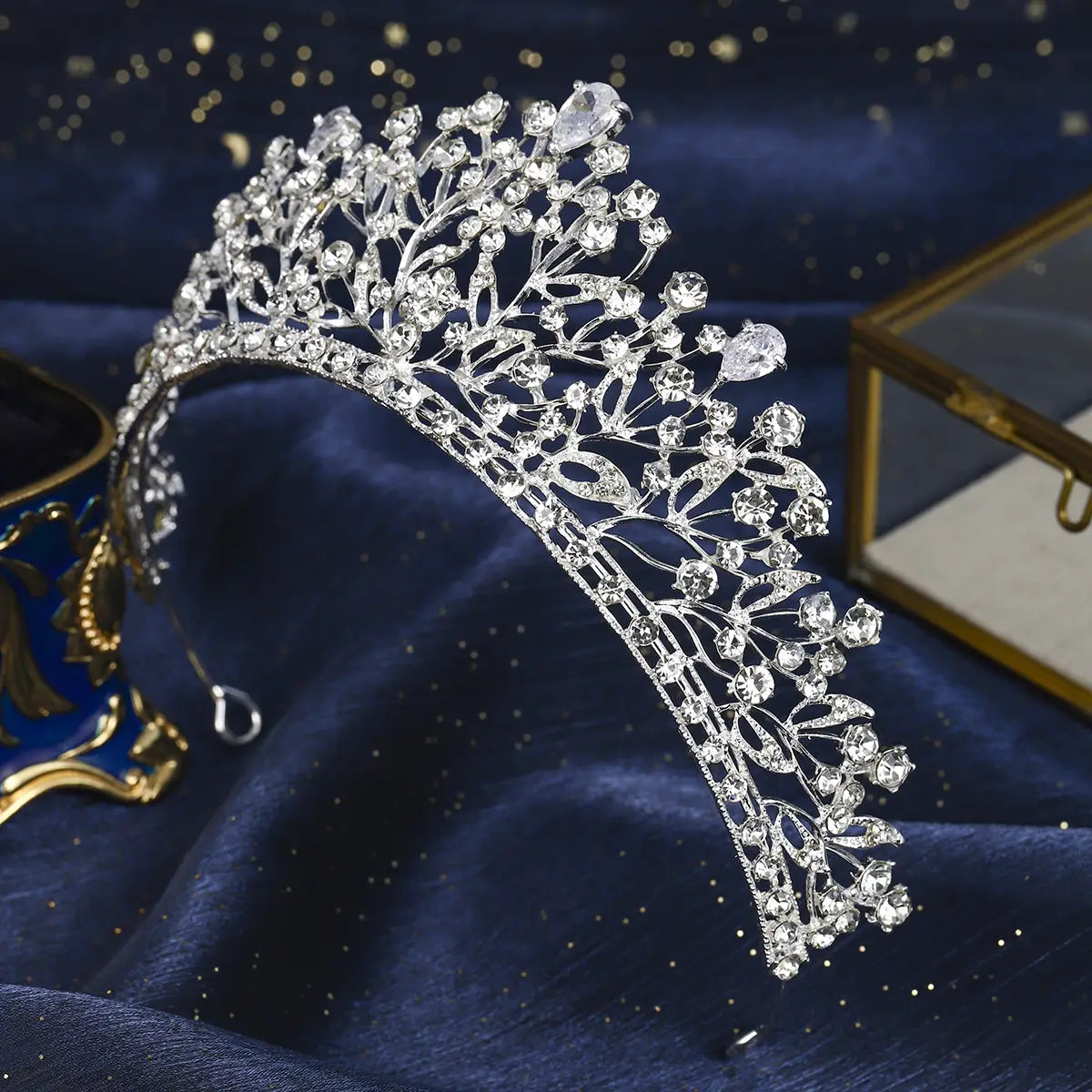 Une tiare de mariage en cristal, couronne de mariage en argent, présentant une tiare argent étincelante, ornée de décorations en cristal complexes et de motifs délicats semblables à des feuilles.