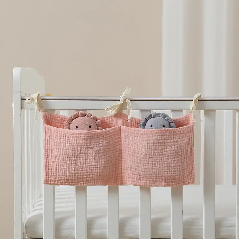 Rosa strukturierte Baumwoll-Aufbewahrungstasche für Babybettchen mit zwei Fächern, jeweils mit einem Plüschtier für die Organisation neben dem Bett