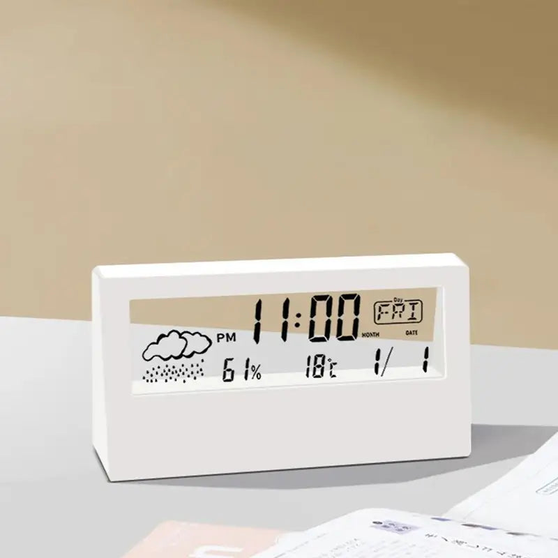 White rectangular digital weather desktop alarm clock displaying time date weather and temperature on a minimalist screen.