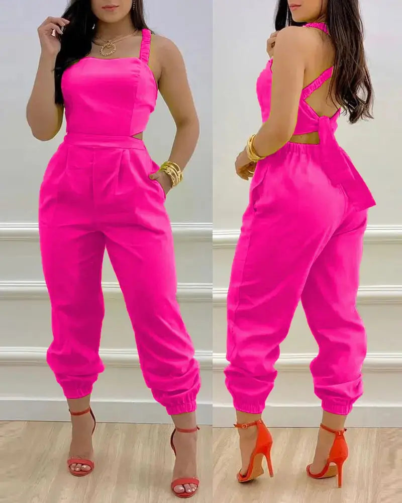 Bright pink sleeveless women summer printed jumpsuit with halter neckline side cutouts and elasticated cuffs.