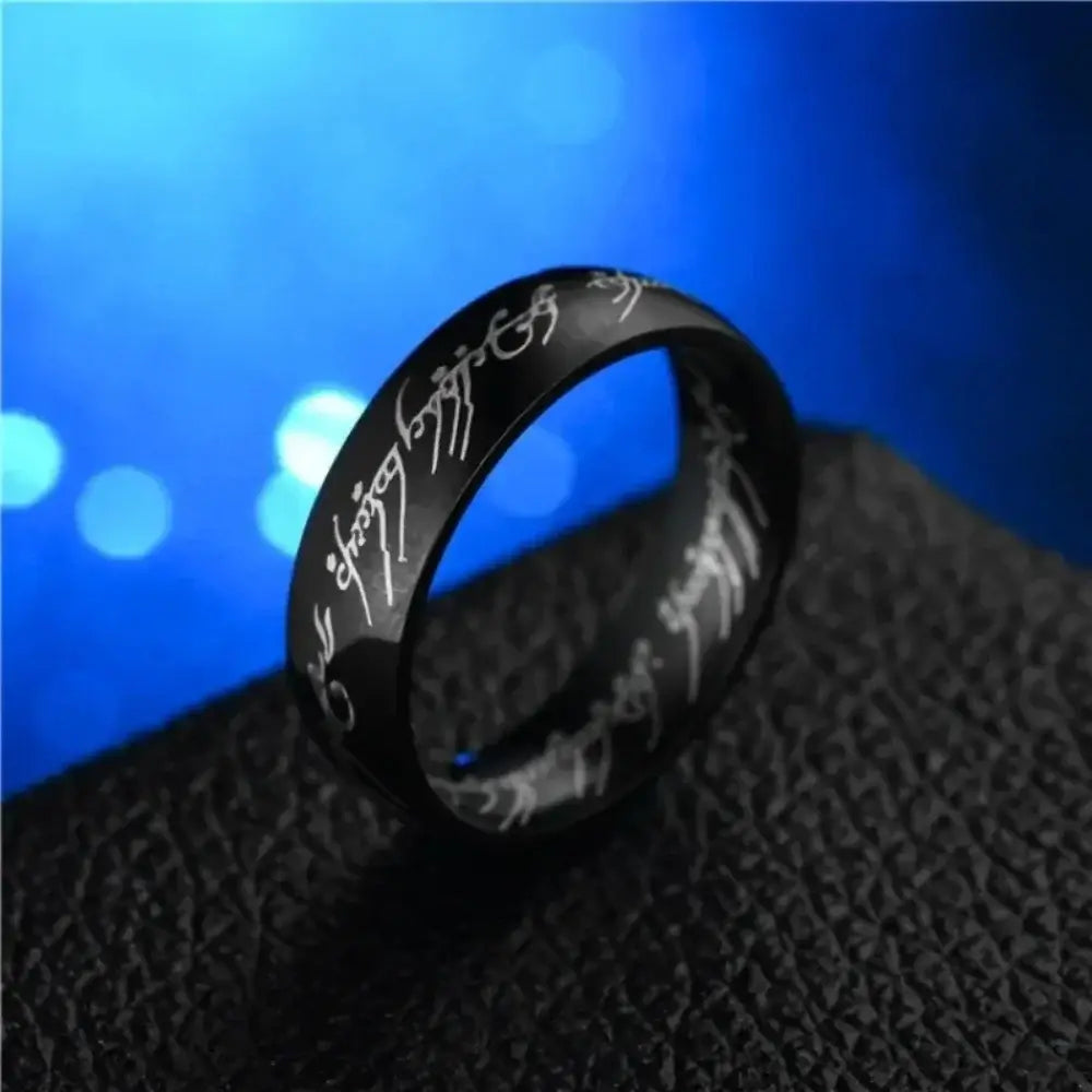 Black stainless steel wedding band ring with white elvish script engraved around the band.