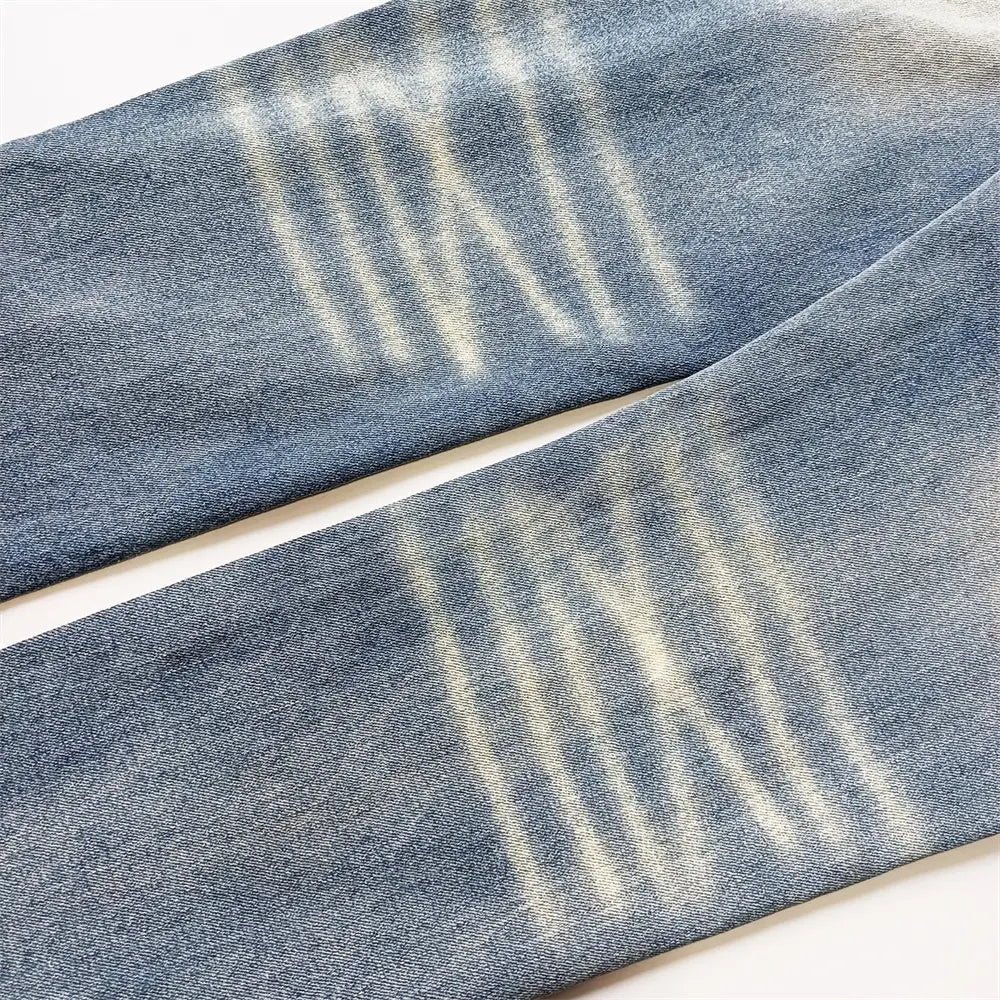 Jeans skinny déchirés pour hommes en denim bleu, avec motif rayé délavé et délavage rétro vintage déchiré.