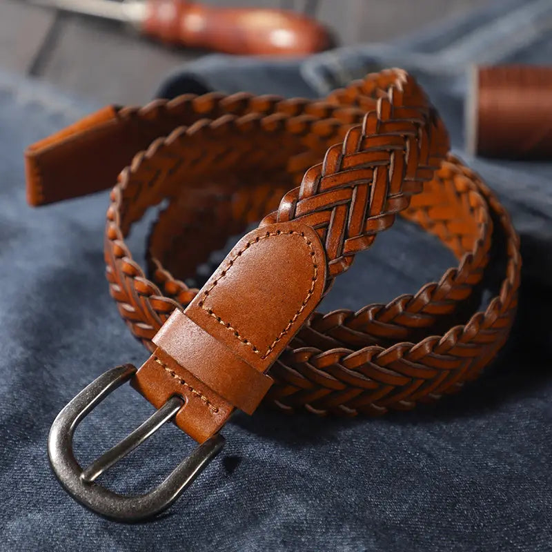 A rich brown braided leather belt with a sturdy metal buckle designed as a unisex casual woven accessory.