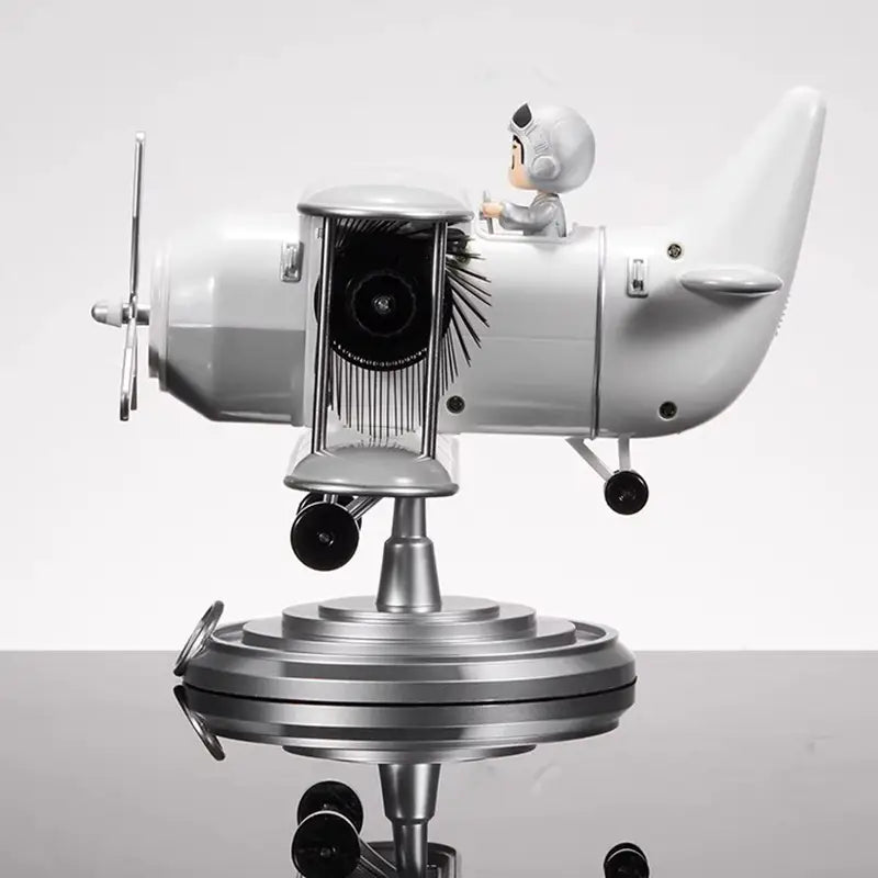 Silver airplane-shaped desk lamp with a cartoon pilot figurine seated inside featuring metallic accents and black rubberized wheels designed as vintage table decor and a flip desk clock.
