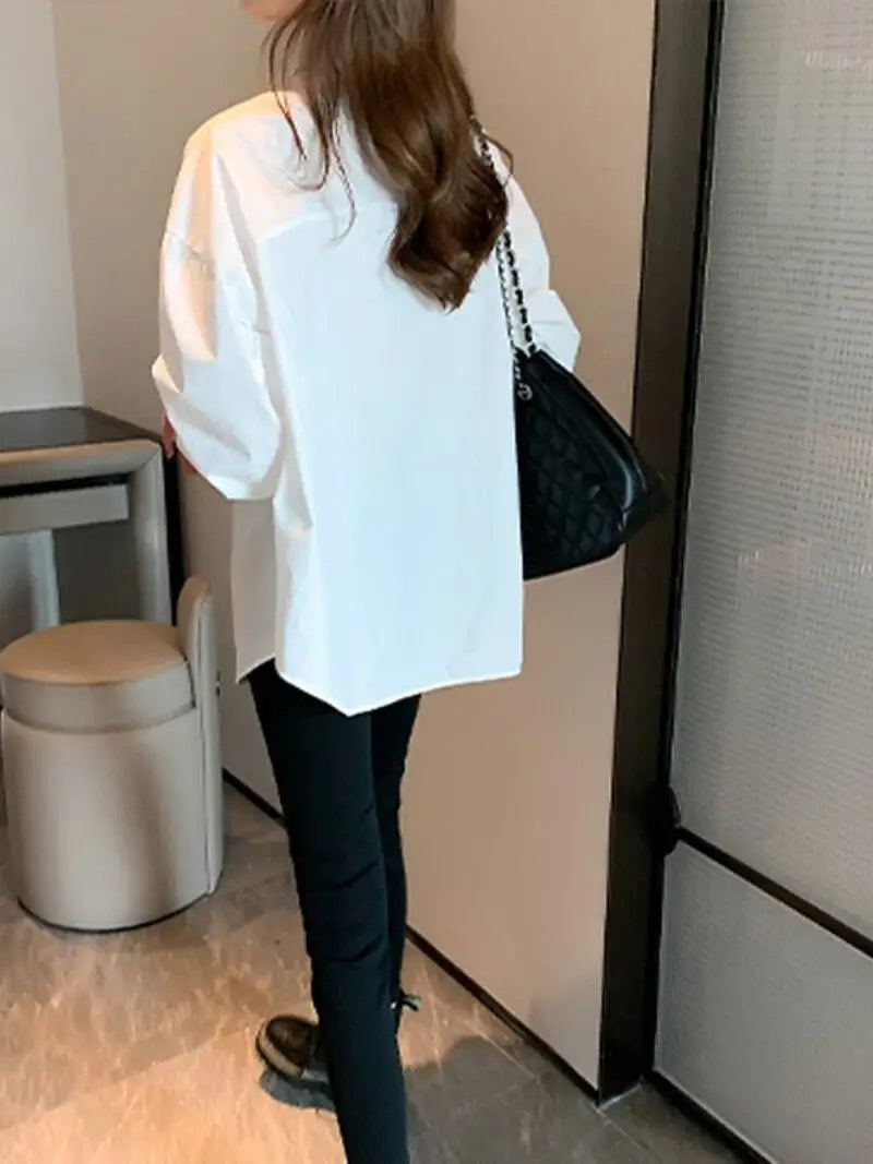 black quilted handbag with silver chain strap placed beside a solid white basic shirt oversized casual button up blouse