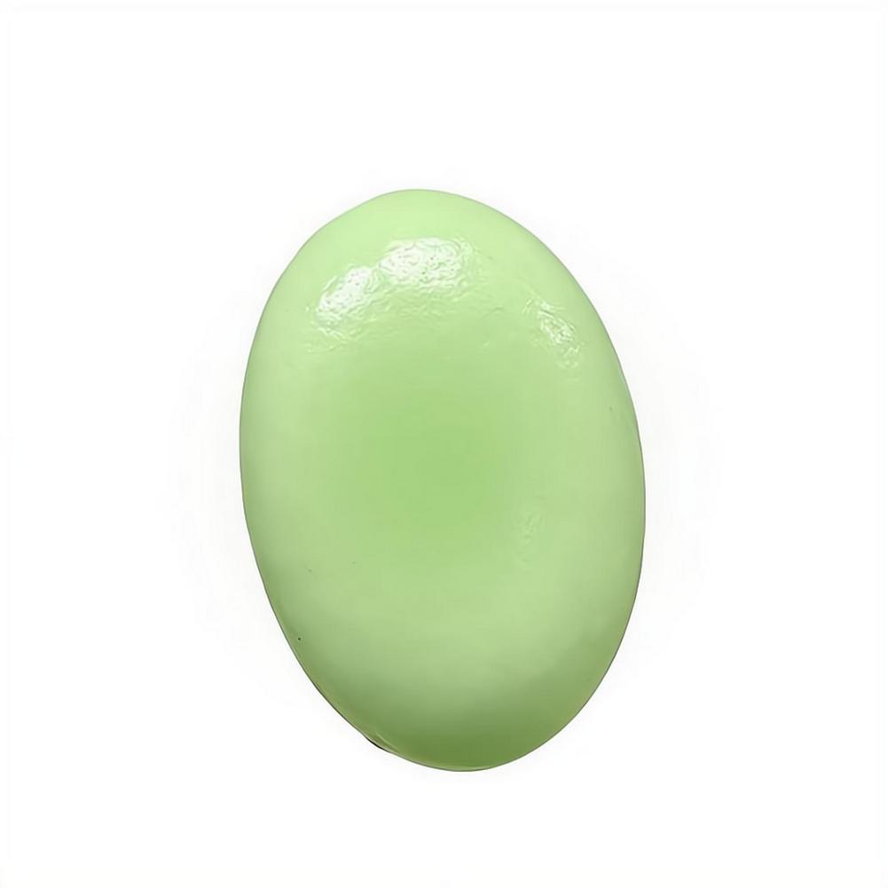 Un pastel de queso lento esponjoso y blando de forma ovalada y suave, color verde pálido, con acabado brillante, diseñado para aliviar el estrés.