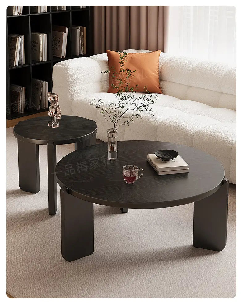 Moderner schwarzer runder Couchtisch mit eleganten minimalistischen Beinen und einer glatten, matt veredelten Oberfläche; er präsentiert die wichtigsten Verkaufsargumente für ein stilvolles Couchtisch-Design.