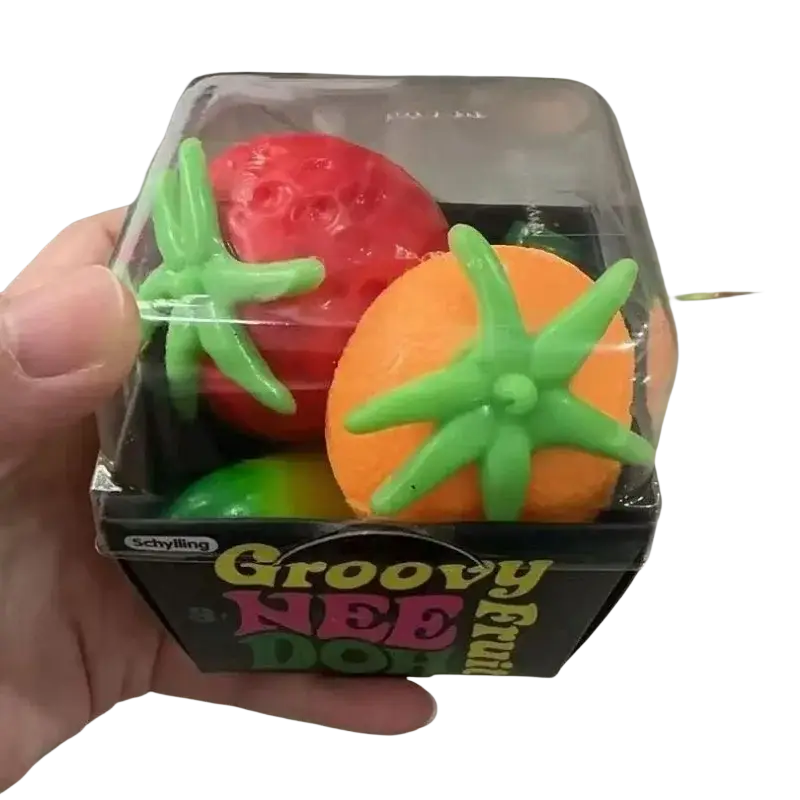 A front view of a vibrant red and orange fruit-shaped stress ball with green leafy tops in a clear plastic box