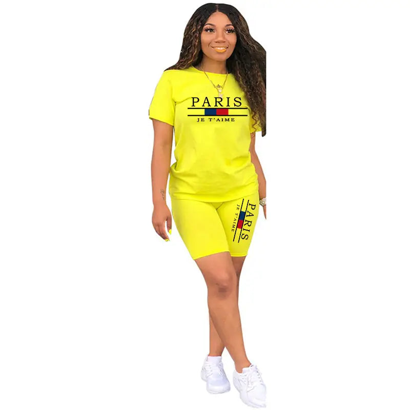 Ensemble deux pièces pour femmes en jaune fluo : haut à enfiler avec fermeture et short, comprenant un haut à manches courtes et des shorts assortis, avec texte « Paris je t’aime » et des rayures horizontales multicolores en bleu, rouge et noir.