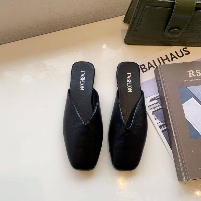Schwarze flache Ledermules mit quadratischem Zehenbereich, einem eleganten minimalistischen Design und glatter Lederoberseite.