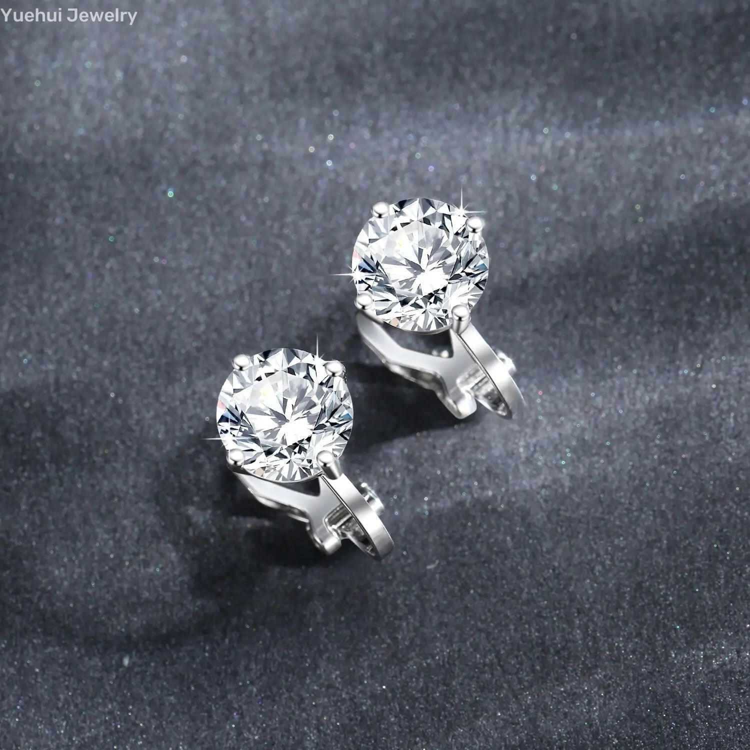 A pair of elegant silver moissanite clip on earrings made of 925 sterling silver featuring round brilliant-cut clear gemstones held by four prongs.