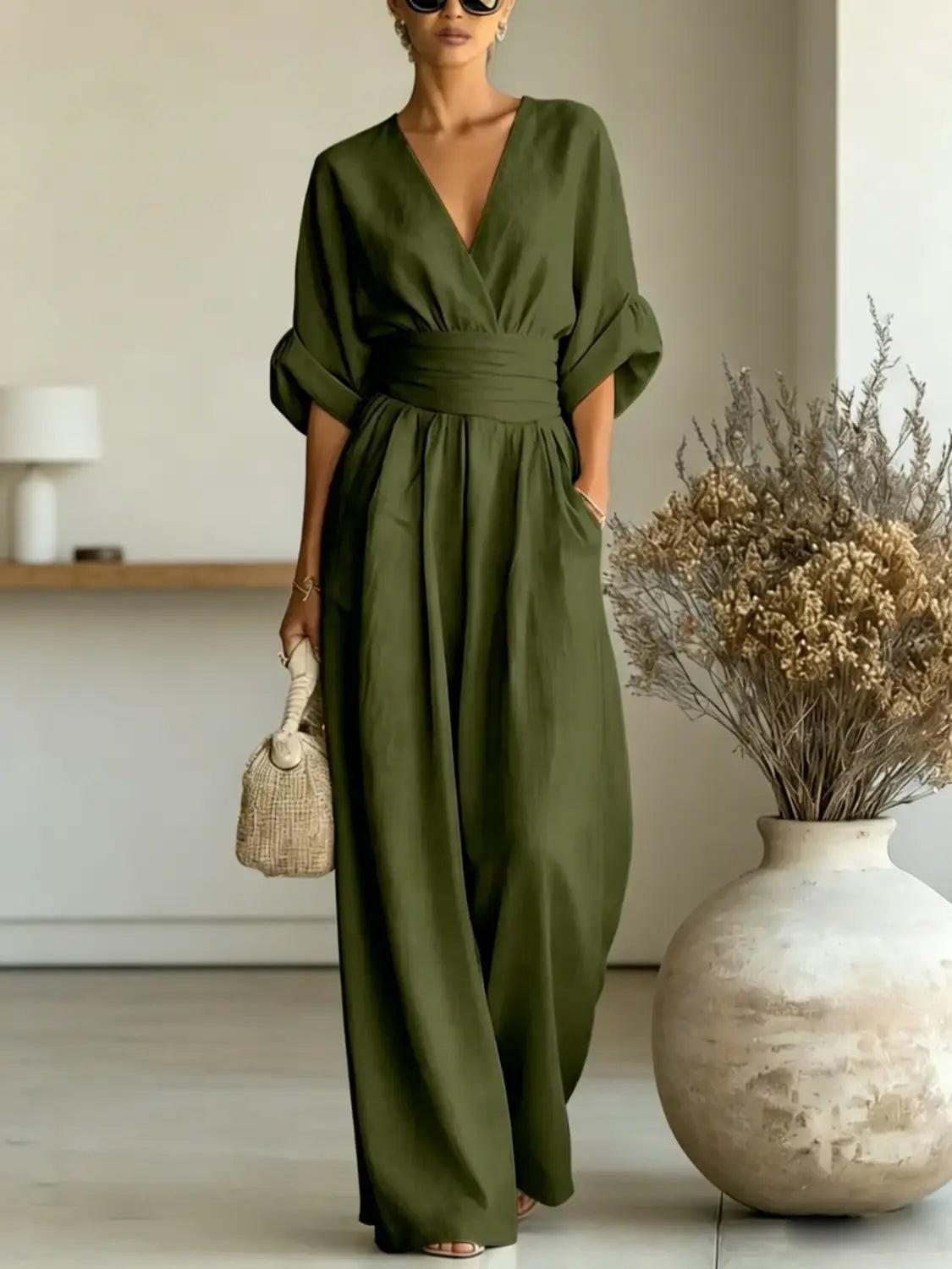 Olive green v-neck wide-leg jumpsuit with a cinched waistband made from lightweight fabric for a comfortable fit.