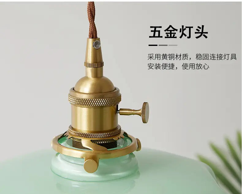Luminaire suspendu de style vintage à finition laiton avec corps cylindrique texturé et tête de lampe en cuivre, comportant des détails décoratifs à rainures.