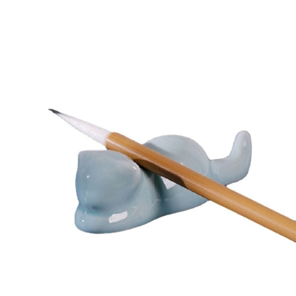 A light blue ceramic pen holder shaped like a cat with a smooth glossy finish designed as a minimalist calligraphy brush rest.