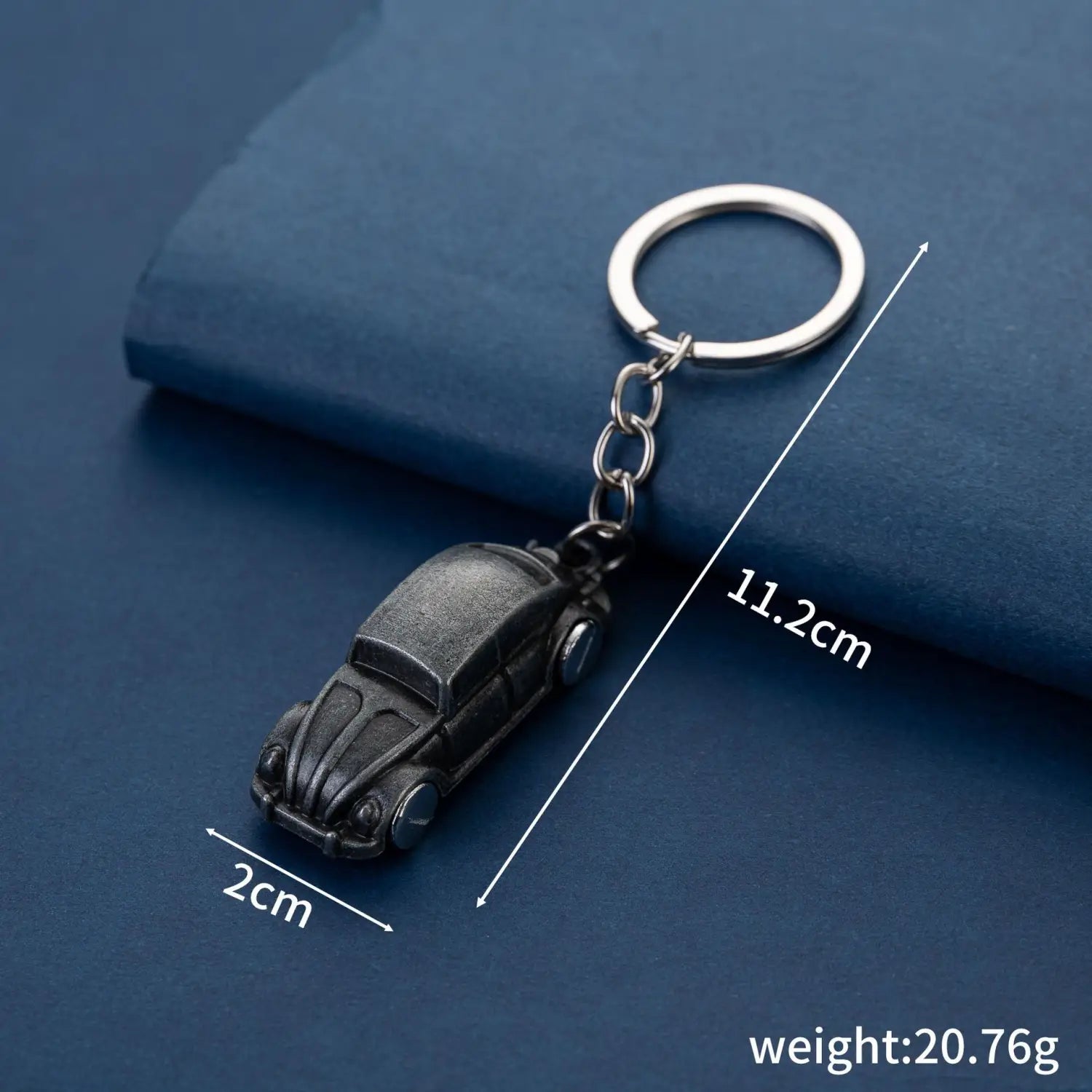 Black vintage-style Volkswagen Beetle metal car keychain with a silver metal ring and chain for holding keys