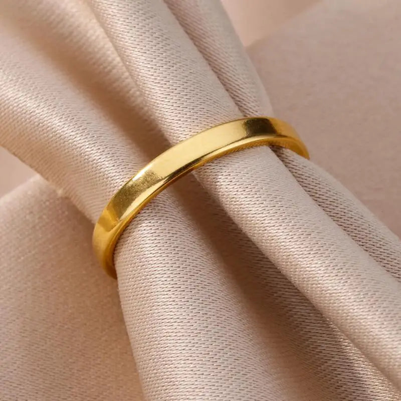 Un anillo pulido elegante de acero inoxidable color dorado para mujeres, con un diseño minimalista y liso, ideal para joyería de boda vintage.