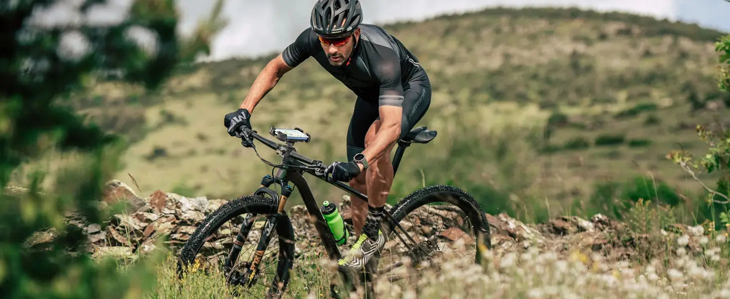 Vélo de montagne noir avec des pneus robustes et une bouteille d’eau verte montée sur le cadre, doté d’un support de téléphone pour vélo universel offrant une rotation à 360 degrés.