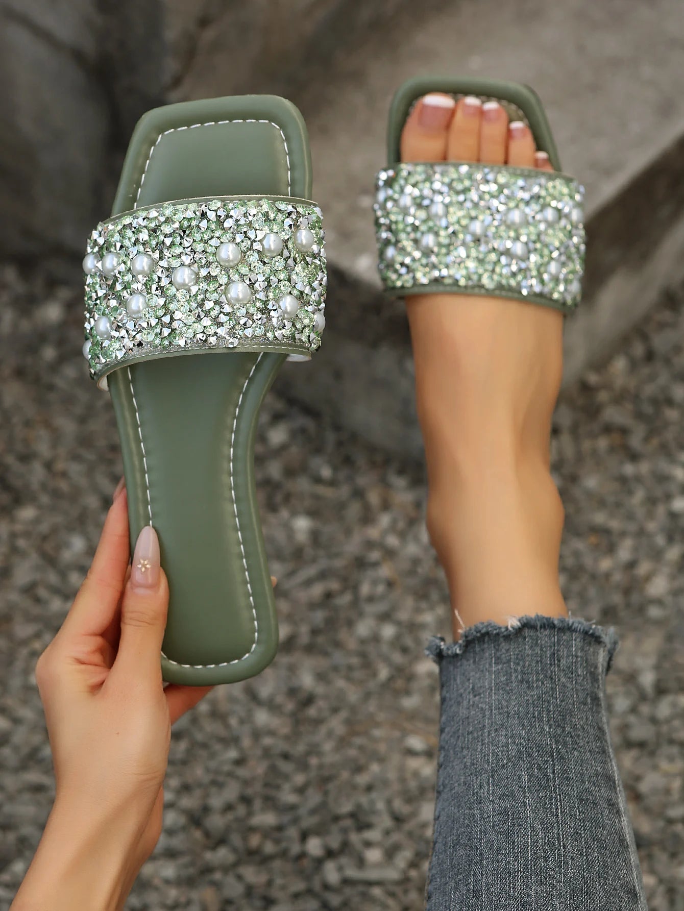 Olive green slide sandals featuring a sparkling band of clear rhinestones and white pearls for elegant flat wear.