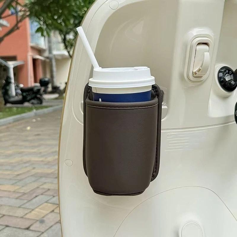 Organizador para asiento de coche y portavasos de cuero color marrón tipo cuero que sujeta de forma segura una taza de café desechable azul y blanca con pajita