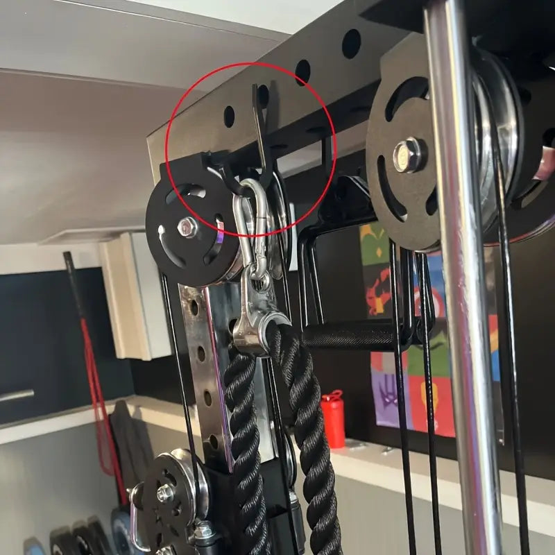 black pulley with silver metal hardware attached to gym machine for squat rack barbell storage holder attachments visible from the back side