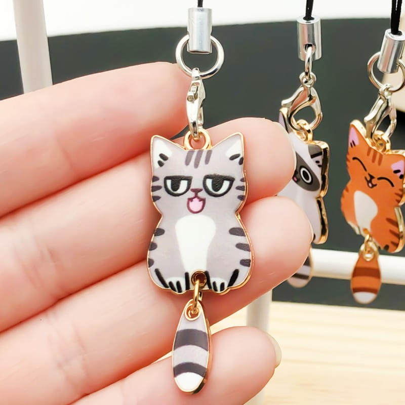 Enamel cat keychain and cute charms featuring a silver and black striped cat-shaped phone charm with enamel detailing and a dangling tail.