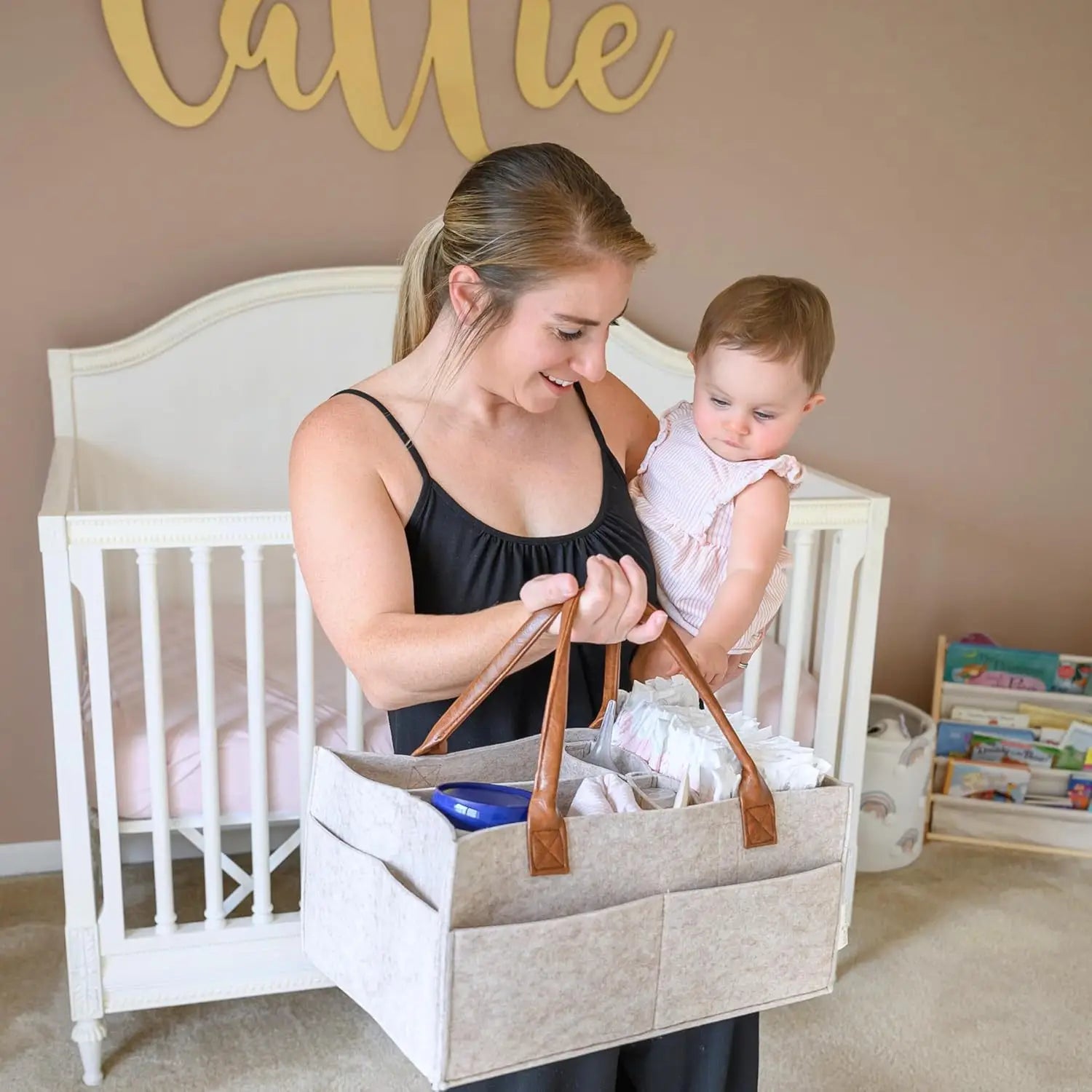 Beige Filz-Wickelunterlagen-Organizer-Tasche für Babys mit braunen Ledergriffen und mehreren Fächern für eine praktische Aufbewahrung.