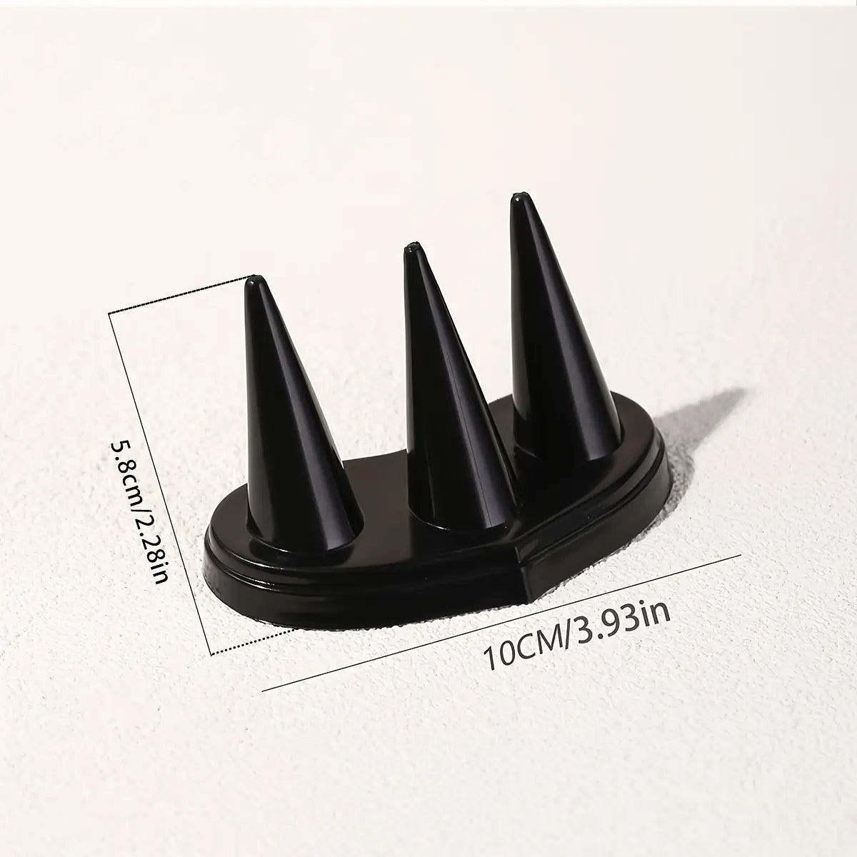 Support d’exposition conique en plastique noir pour bagues, avec trois pointes pointues destinées à un placement sécurisé de la bague.