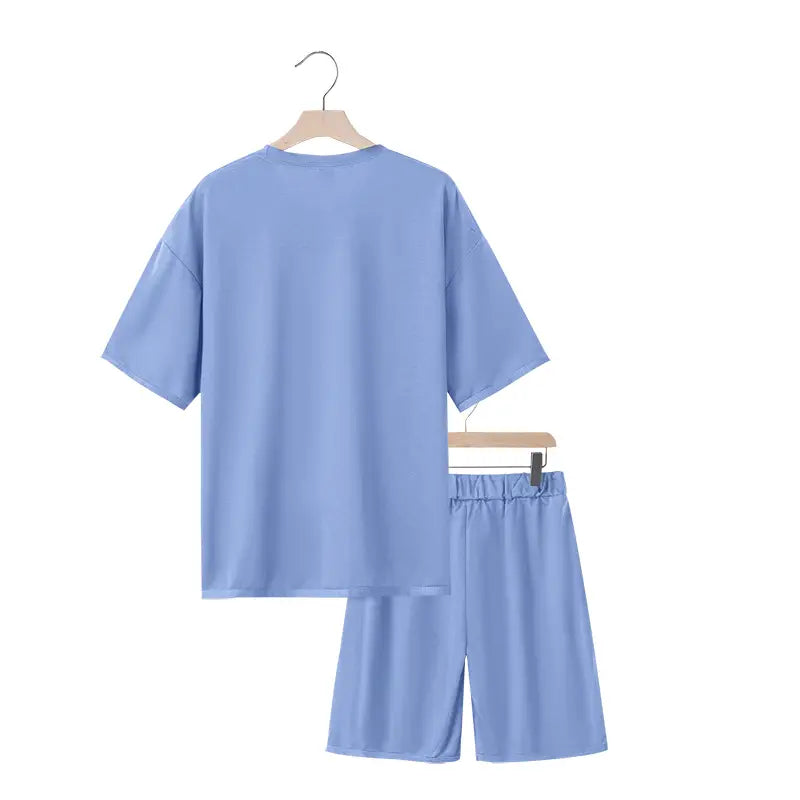 Conjunto veraniego de dos piezas para hombre en algodón suave con textura color azul claro, con camiseta casual y pantalones cortos con cintura elástica.