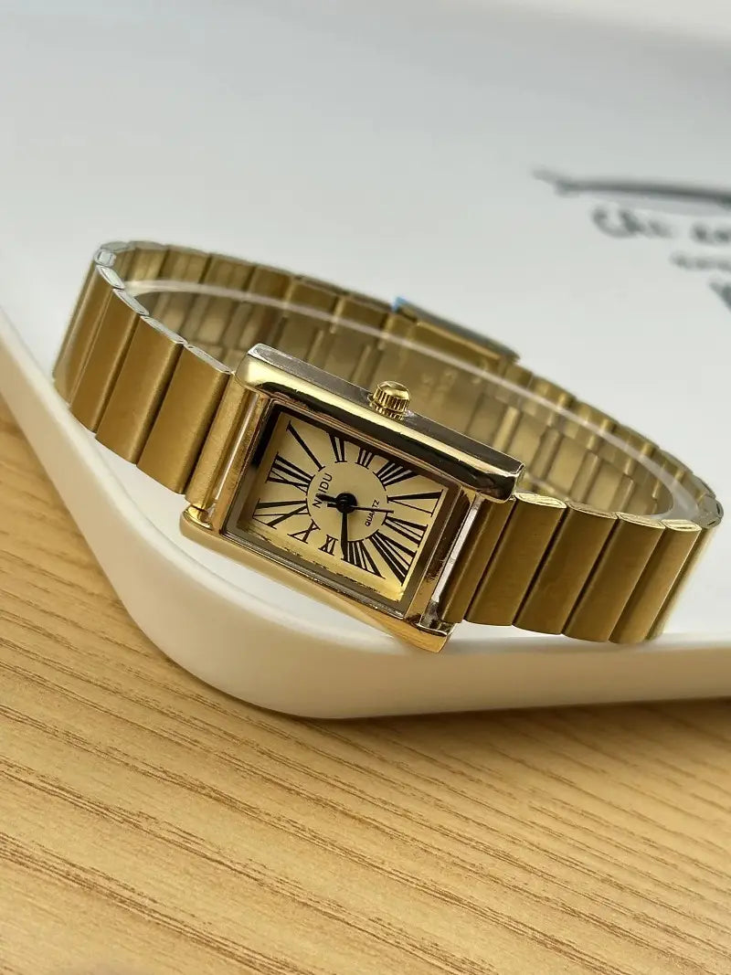 Vintage gold rectangular quartz watch for women with a gold-toned metal bracelet and a classic roman numeral dial.