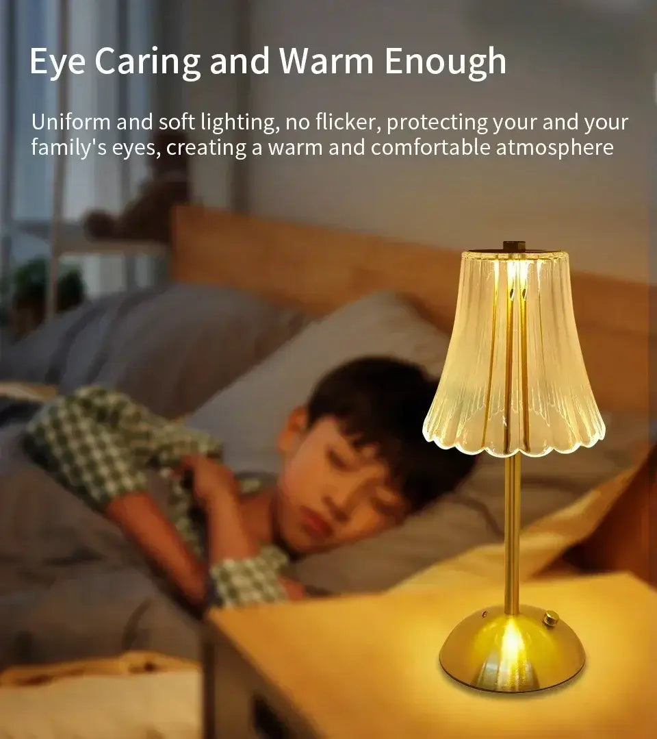 Goldfarbene wiederaufladbare Tischlampe mit einem transluzenten gerillten Glasschirm als warme Lichtquelle.