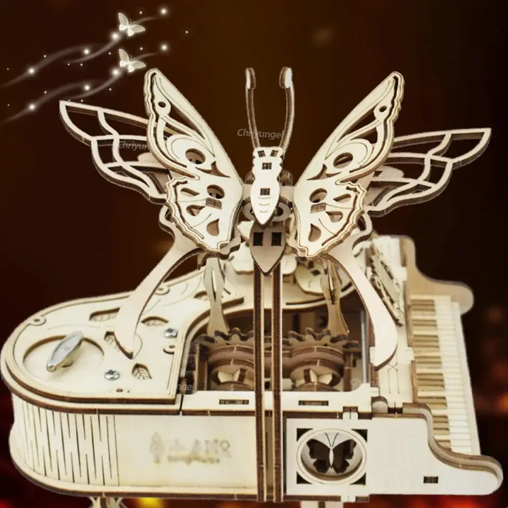 ein zartes, kunstvoll ausgeschnittenes hölzernes Schmetterlingsmotiv, das auf einer Miniatur-Klavier-Musikbox mit sichtbaren Zahnrädern und Tasten in einem 3D-Holz-Puzzle-Bastelset thront