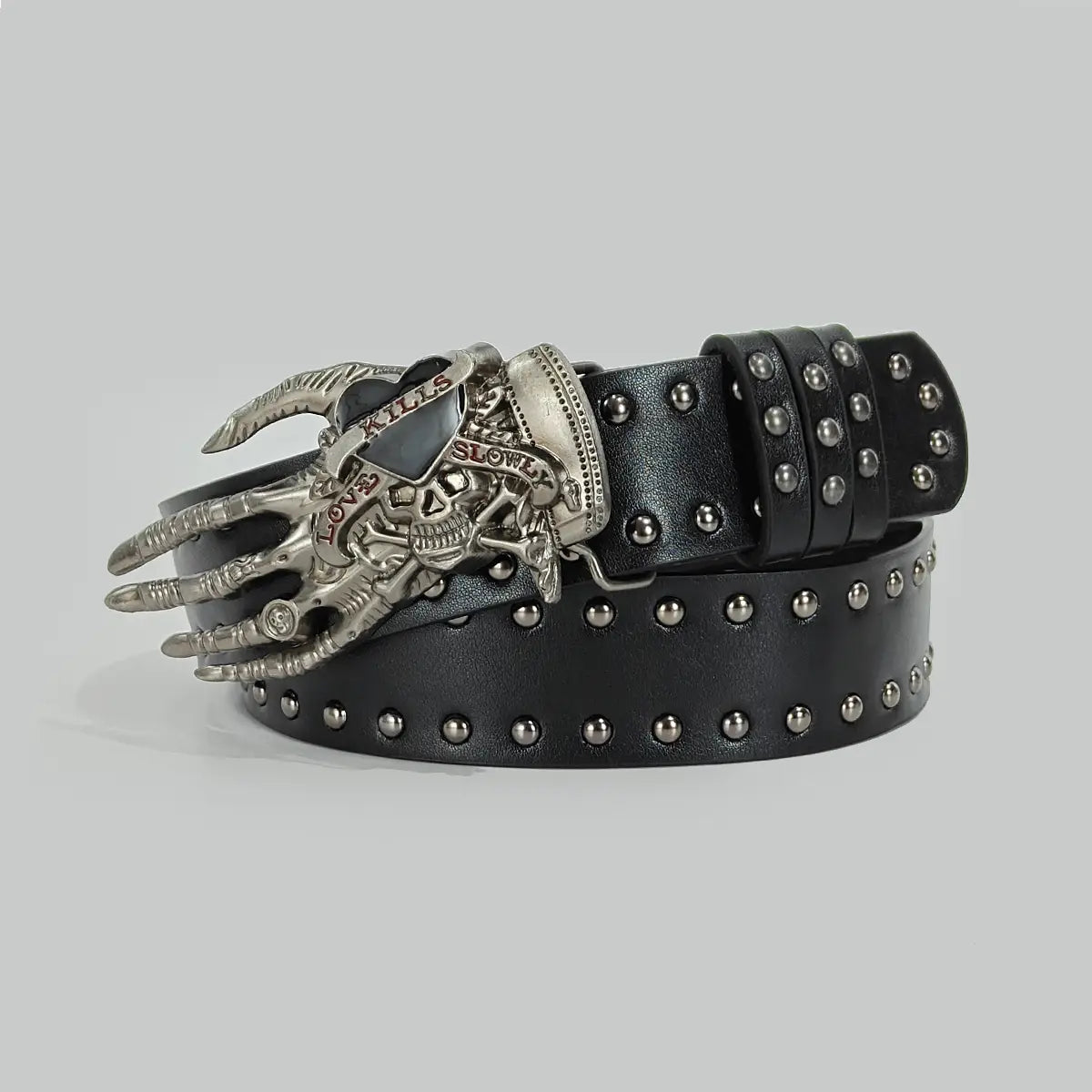 cinturón de cintura negro de cuero en estilo y2k con diseño con tachuelas en tono plateado y hebilla detallada de mano con calavera que presenta un estilo y2k de cruz bohemia