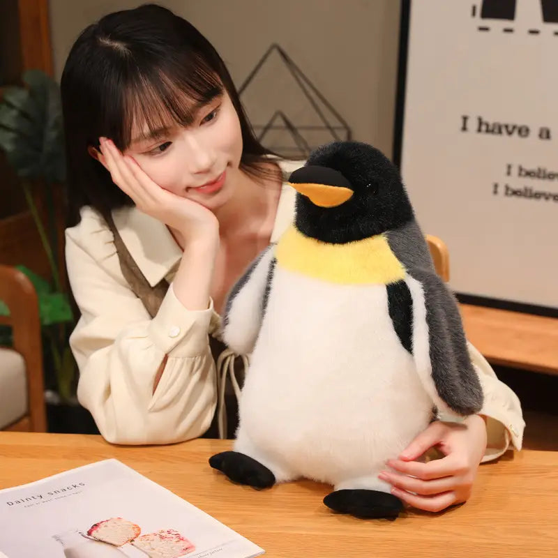 A plush penguin stuffed animal soft toy pair featuring a black head, yellow beak and chest band, gray wings, white belly, and black feet.